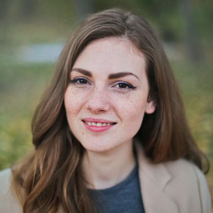 a woman with freckled hair is smiling for the camera.