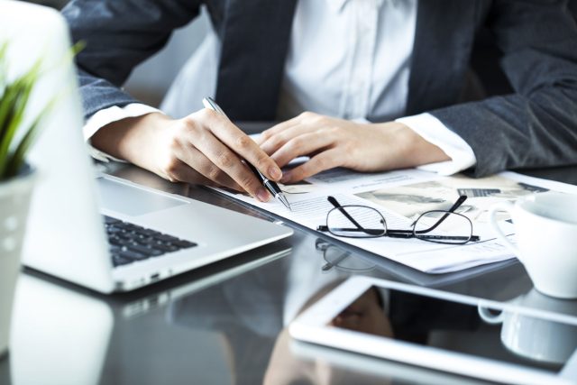 a person sitting at a desk working on a laptop.